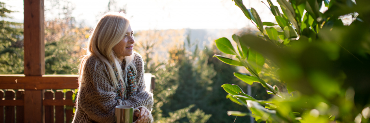 Why I Used to Wish My Fibromyalgia Pain Was Visible Woman on deck in forest.
