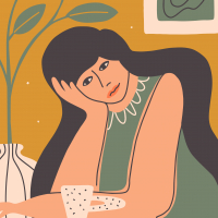 Tired woman sitting at table resting head on hand.