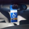 Disabled parking permit hanging in the window of a car.