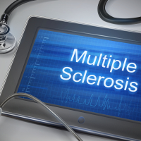 Multiple sclerosis words displayed on tablet with stethoscope on table.