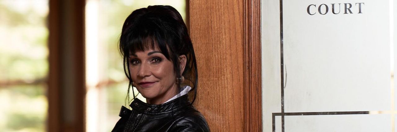 Interview With Judge Rosemarie Aquilina on Sexual Assault and Trauma Judge Rosemarie Aquilina standing against the door of a courtroom smiling