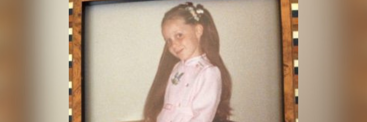 The Difference Between Blaming Abusive Parents and Holding Them Accountable  Photo frame of the author as a young girl in a pink dress smiling