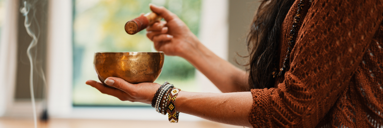 photo of a person close up with a singing bowl and incense, meditation concept for ADHD treatment