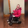 Grace sitting in her power wheelchair.