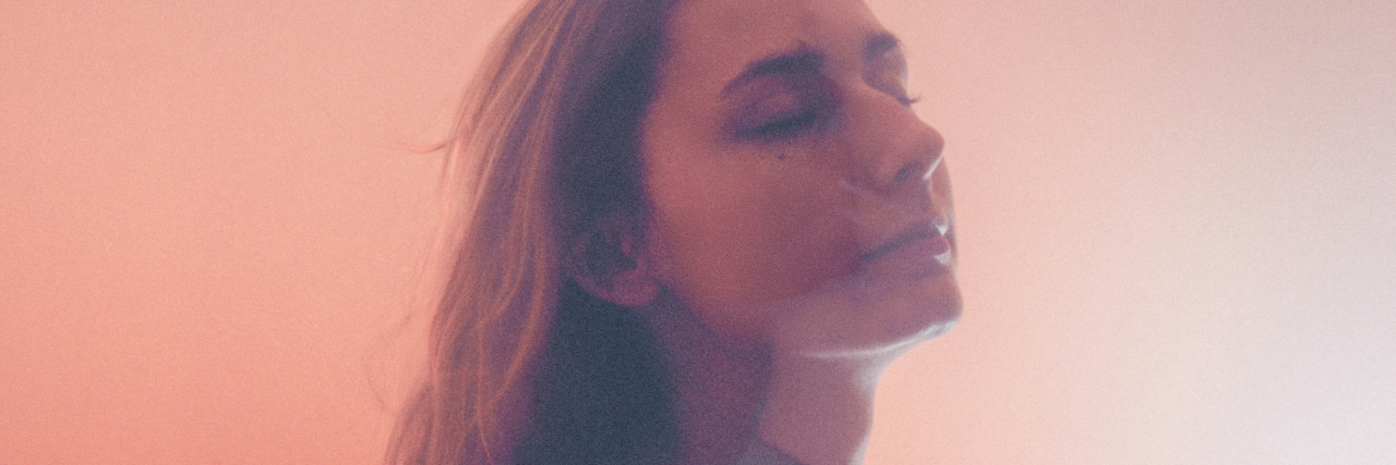 Schizoaffective Disorder Stole My 20s -- Here's How I Feel Now photo of a woman in hazy environment with her eyes closed