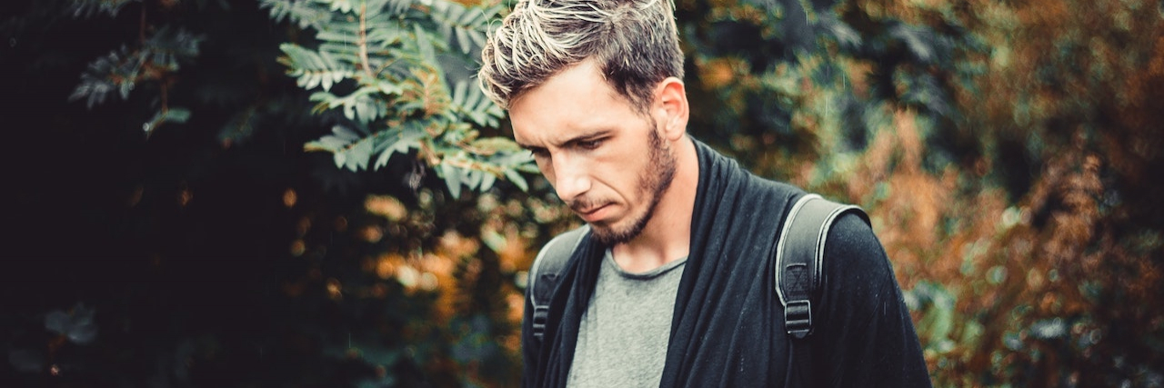 The Connection Between Childhood Sexual Abuse and Suicide A man walking in the forest wearing a backpack