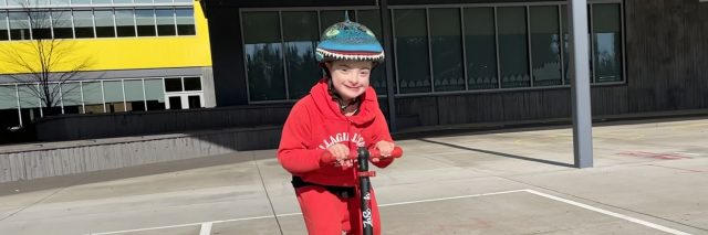 Deena's son riding a scooter.