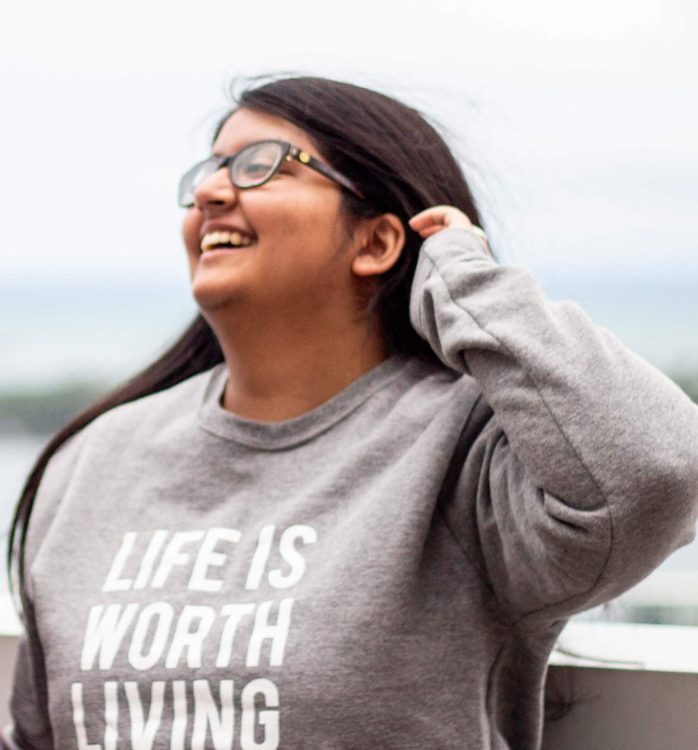Ameera wearing a shirt that says "Life is worth living."