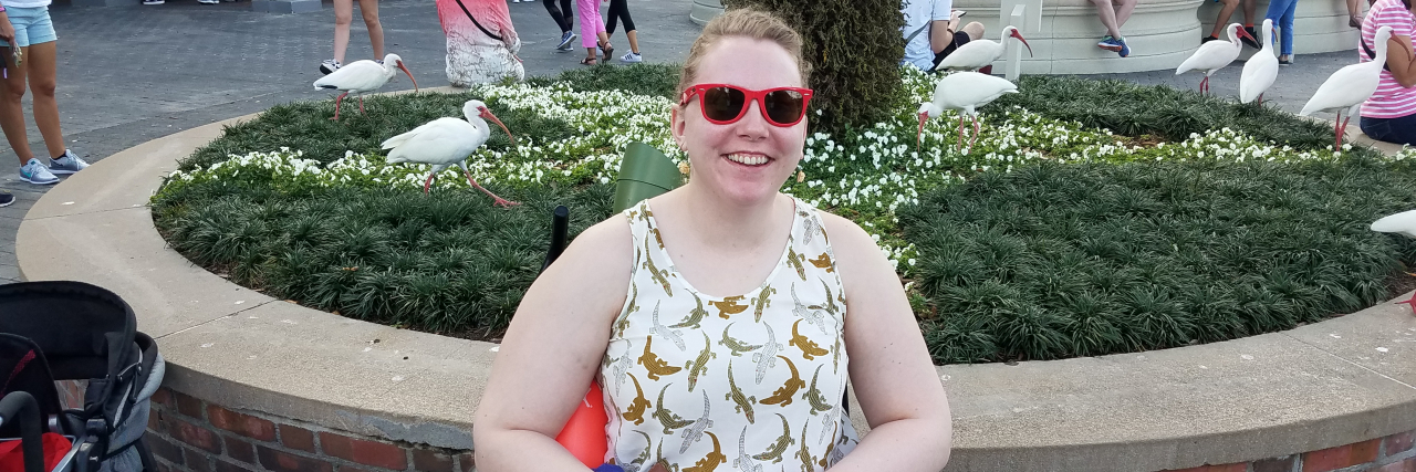 Learning to Accept Using a Wheelchair for POTS Genny sitting in her wheelchair at Disney World.