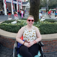 Genny sitting in her wheelchair at Disney World.