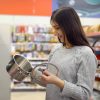 Young woman in a home-goods store chooses a saucepan.