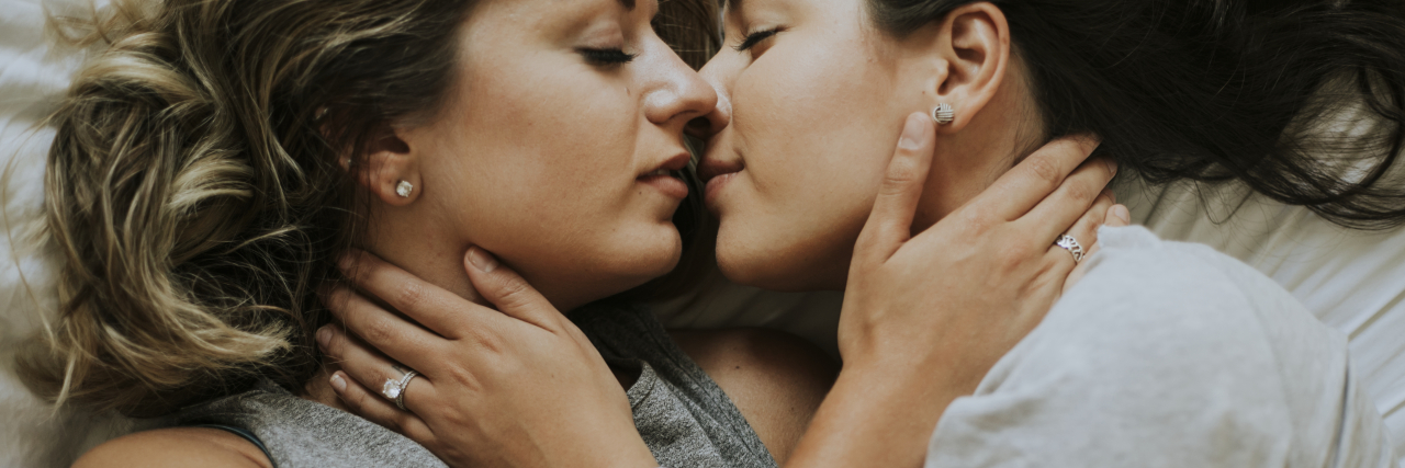 Can Sex Really Provide Migraine Relief? Lesbian couple kissing in the morning.