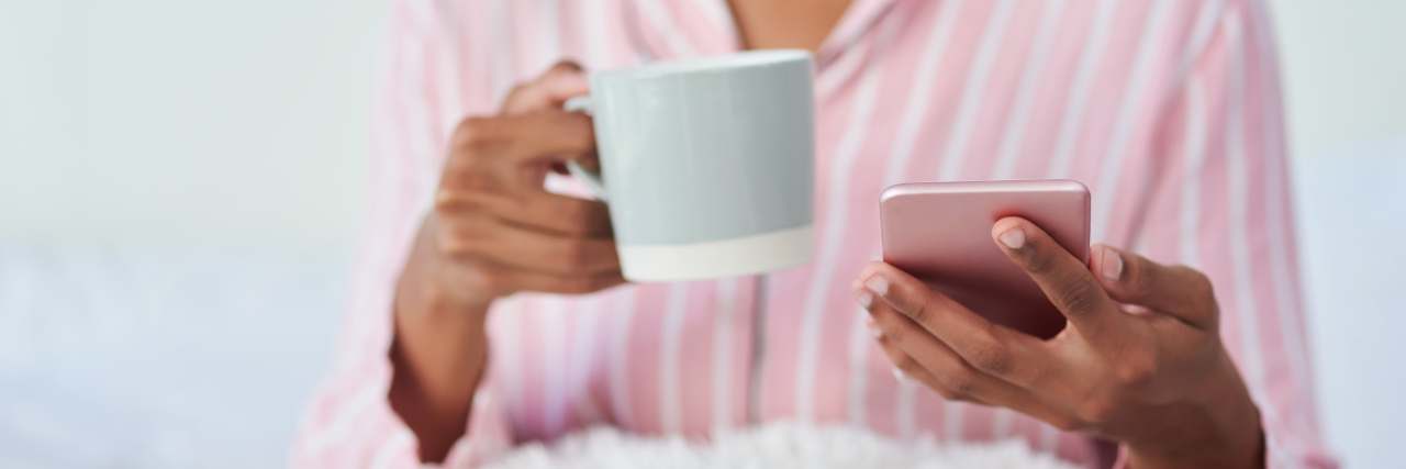 Tracking Your Periods When They're Irregular as Hell (Thanks, Endometriosis) Woman in pajamas using smartphone.