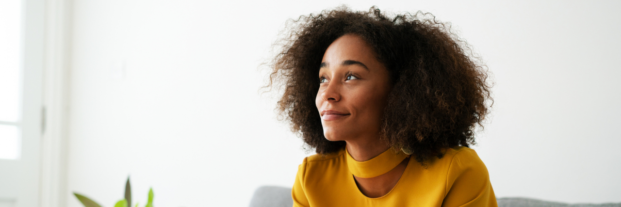 6 Reminders That Healing After Sexual Violence Is Possible (and 6 More Messages of Support) photo of a woman sitting on a couch with her phone, looking peaceful