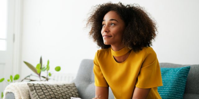 6 Reminders That Healing After Sexual Violence Is Possible (and 6 More Messages of Support) photo of a woman sitting on a couch with her phone, looking peaceful