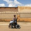 African woman using power wheelchair.