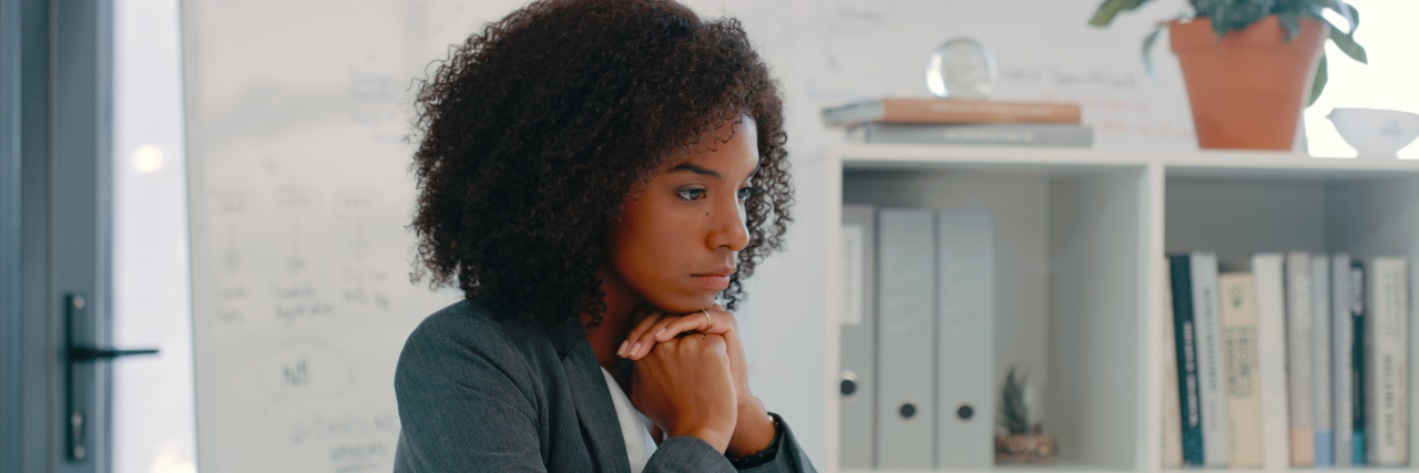 Trying to Cope With Abortion Law News as a Survivor of Sexual Abuse Woman sitting on at the table with hands folded looking ahead seriously