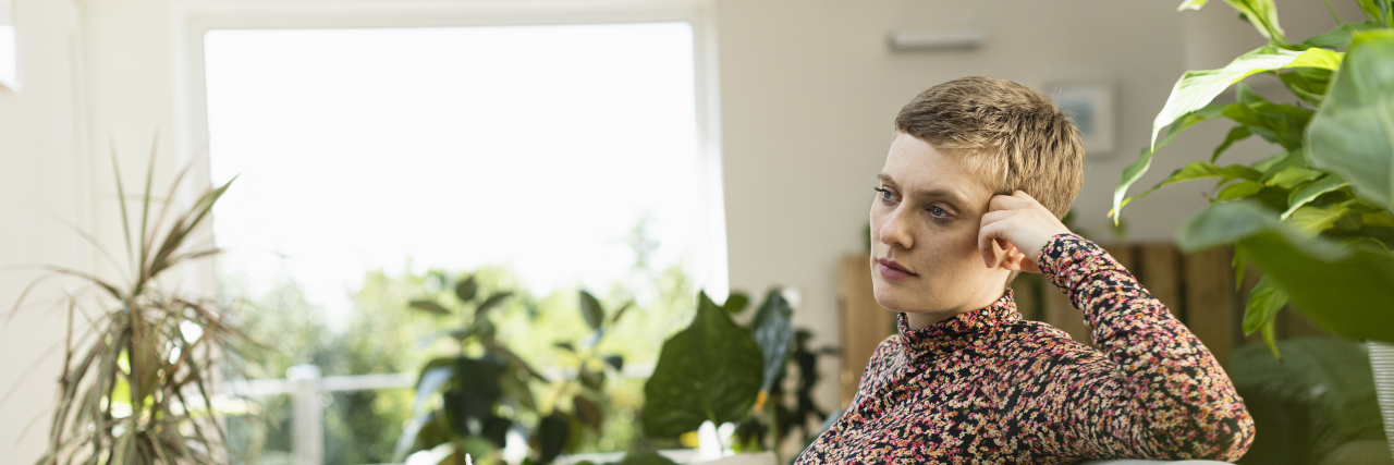 How Endometriosis Absolved Me of My Guilt Over Not Procreating Thoughtful woman sitting on sofa.