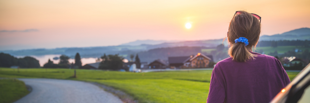 6 Tips for Letting Go of Guilt From Mental Illness and Addiction Young woman sitting on a car, enjoying the sunset
