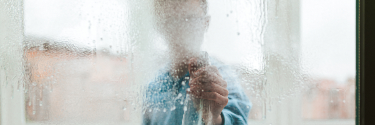 Sensory-Friendly Cleaning Hacks for Neurodivergent People Portrait of a Window Cleaner Looking Through and Cleaning a Window