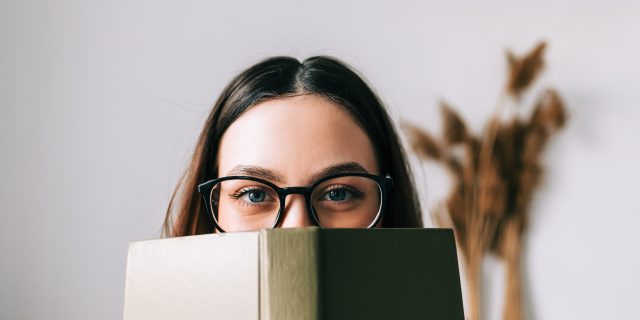 Why Does a Book About My Illness Assume I'm Not Reading It? Woman looking over the top of a book.