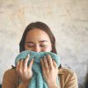 photo of a young woman smelling a towel