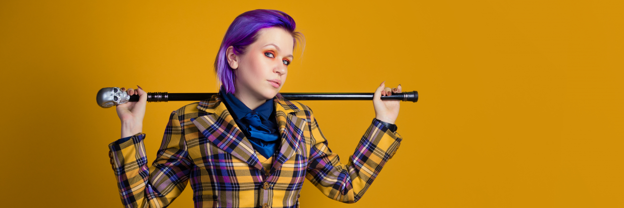 When I Realized Disability Isn't Binary Stylish informal young woman in a three-piece suit with a cane.