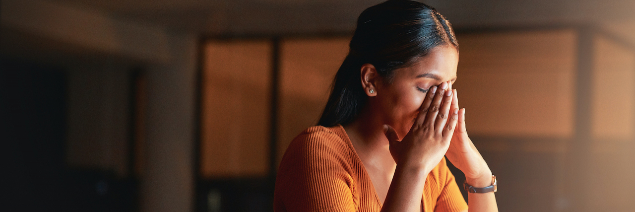 How to Identify, Prevent, and Address Burnout Woman sitting at desk holding her head in her hands
