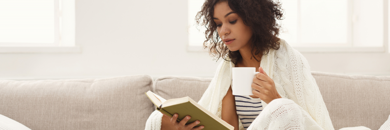 12 Simple, Easy Health Tips That Are Actually Helpful Woman reading book on sofa.