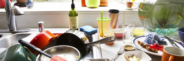 Dirty dishes piled in kitchen sink, close-up