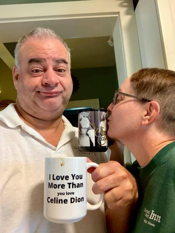 Monika with her husband, who is holding a mug that says "I love you more than you love Celine Dion."