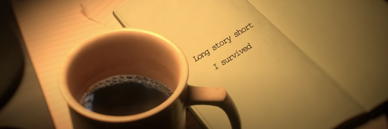 On a page there are typed words "Long story short I survived" with a mug of coffee next to it.