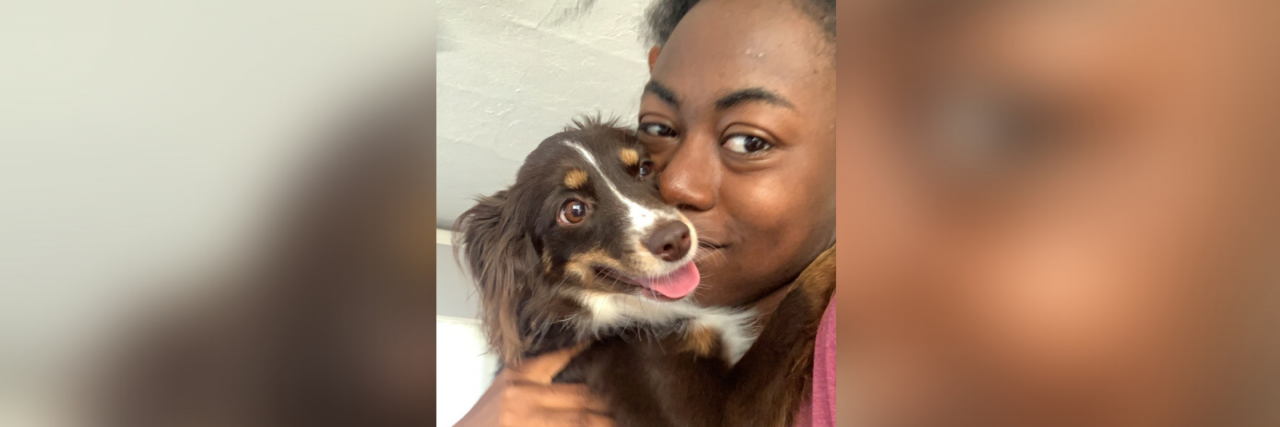 Why Self-Improvement Burnout is Harmful A beautiful girl who is literally just so beautiful stares into the camera while holding her dog, a very annoying but also very cute mini aussie who is smiling wide.