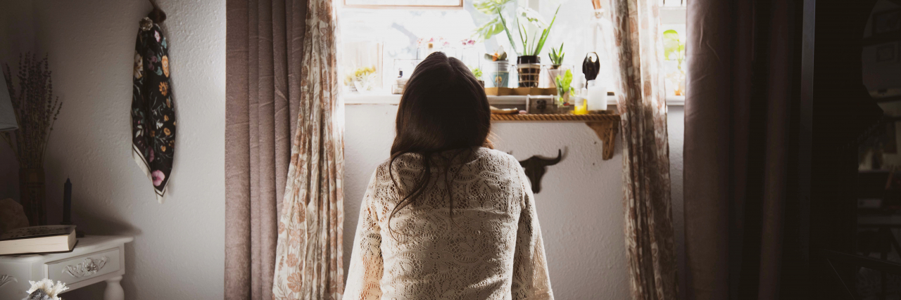 What Is 'Behavioral Activation' and How Could It Help Your Depression? photo of a woman sitting on the edge of a bed looking at the window