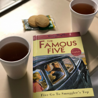 Cookies, tea, and Famous Five book on a hospital tray.