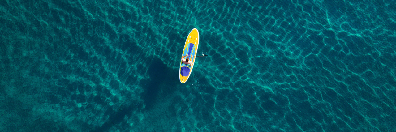 Feeling Lost With Autoimmune Disease and Chronic Illness Aerial view of a person in a kayak in the ocean.