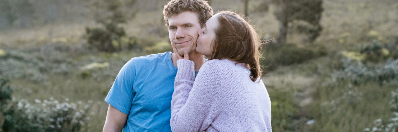 Signs You’re a Codependent Person – and How to Break Free photo of a couple with the woman kissing the man's cheek while he looks away