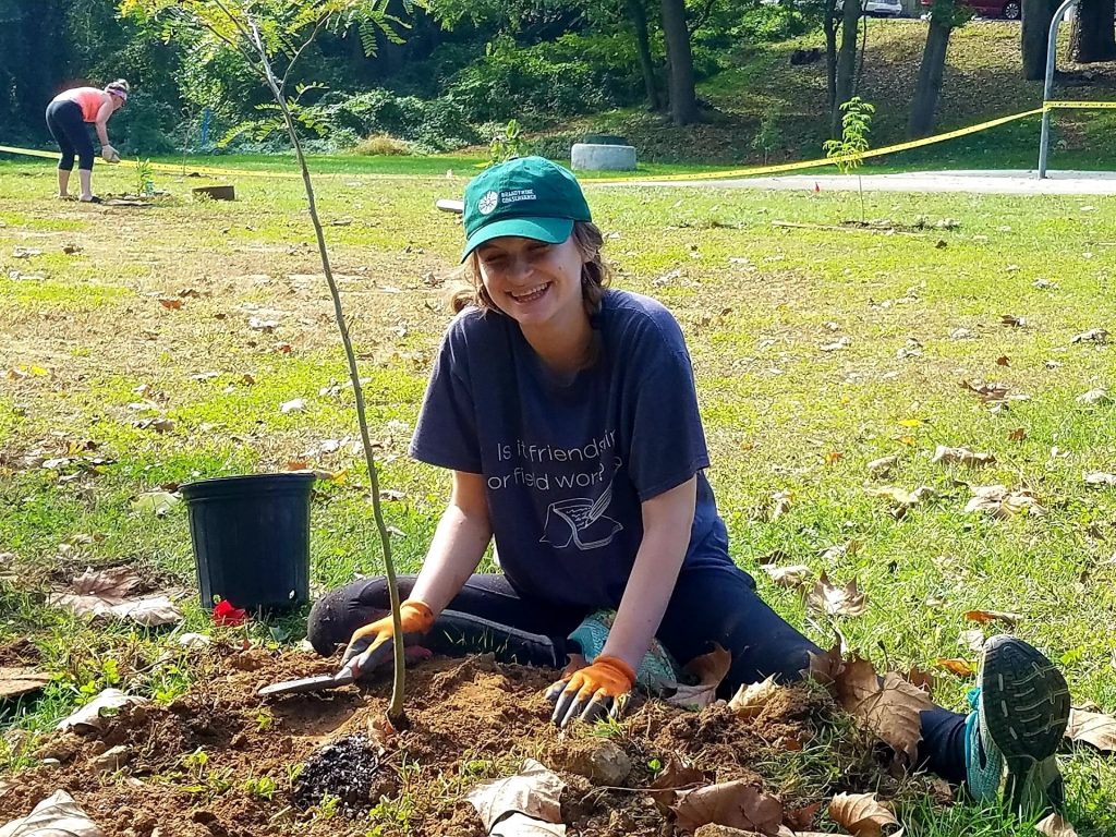 photo of the author, Mighty editor Skye Gailing, planting a tree and smiling