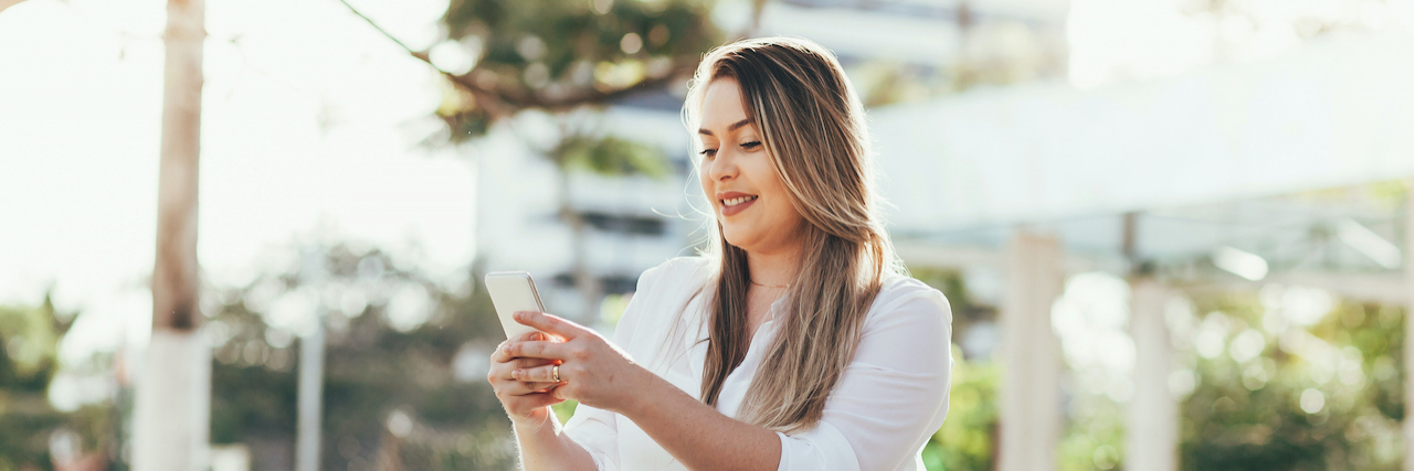 Woman sitting outside looking at her phone