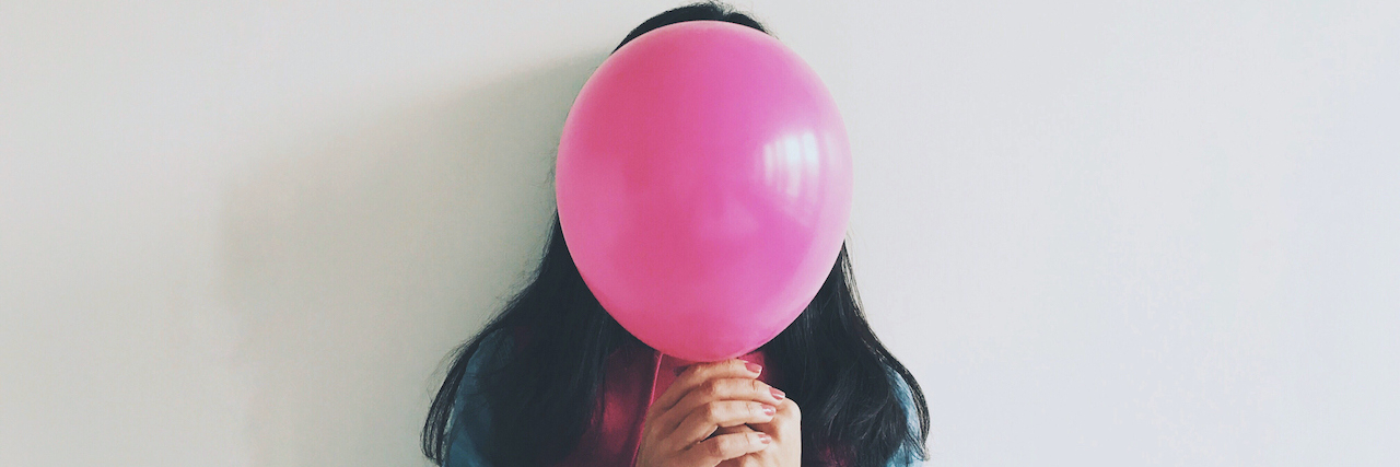 When You Get What You Want and Happiness Still Eludes You Woman Covering Face With Balloon Standing Against Wall