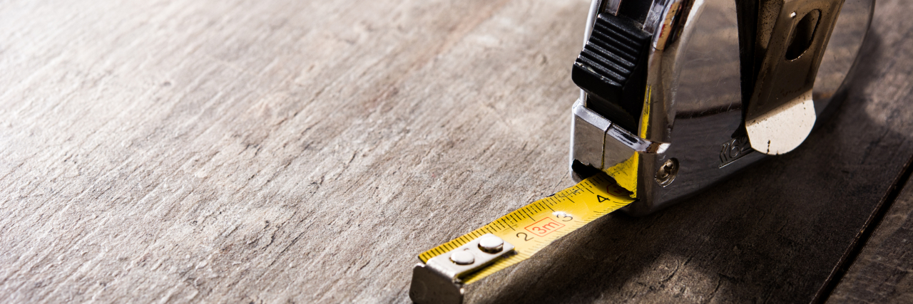 How to Take Action Against ADA Access Violations Measuring tape on wooden table.
