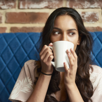 photo of a young person on a blue couch with a large mug partially hiding face