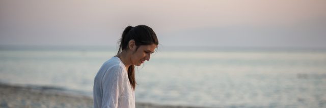 Young woman with hearing aid on the beach.