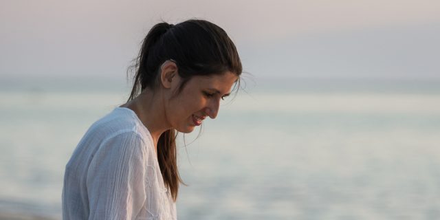 Young woman with hearing aid on the beach.
