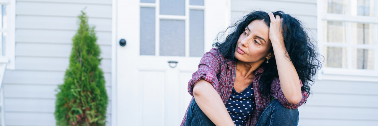 When Endometriosis Meets Menopause: A Recipe for Disaster Middle-aged woman sitting on stairs in front of her house.