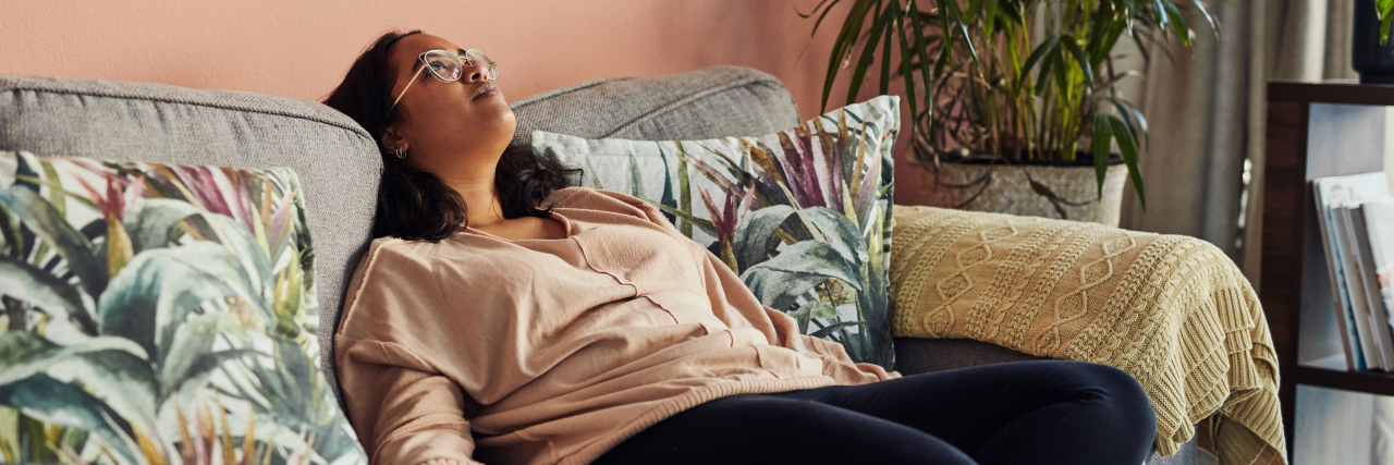 Marking My 'Lost Years' With Myalgic Encephalomyelitis Young woman resting on the sofa at home.