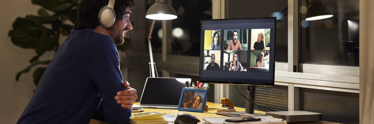photo of a man on a video call late at night with multiple other people