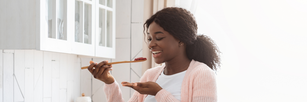 9 Spoonie Cooking Hacks to Save Time and Energy in the Kitchen Cooking with chronic illness: Woman tasting food in the kitchen.