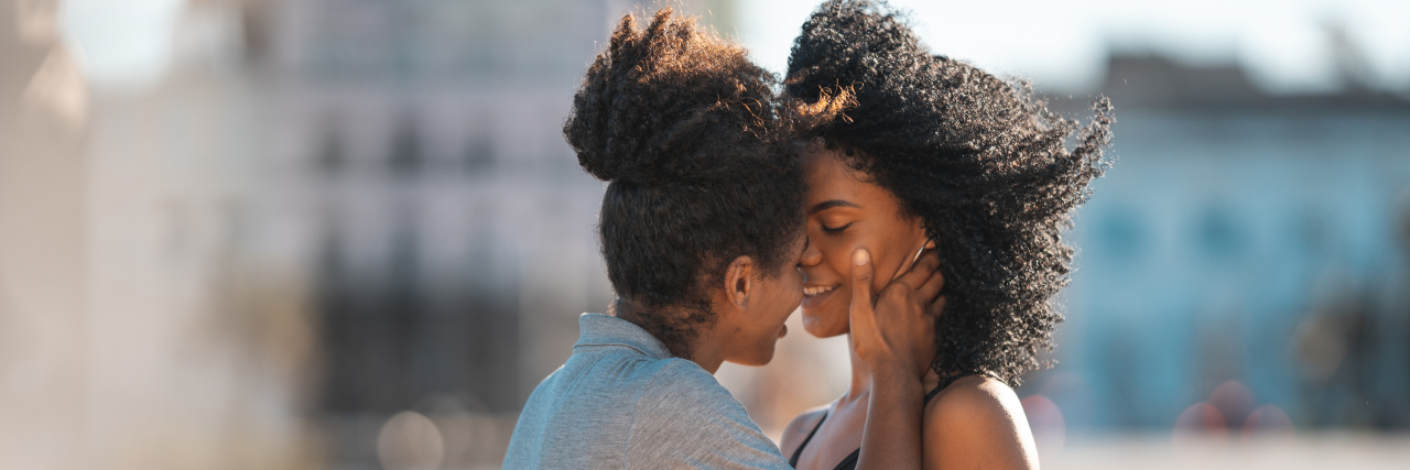 4 Tips for Overthinking and Anxiety in Relationships Lesbian couple kissing on the mouth outdoors