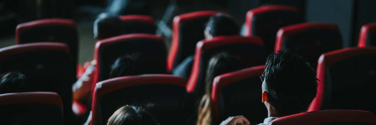 Why Going to Movie Theaters Is Hard as an Autistic Adult People in movie theater, rear view.